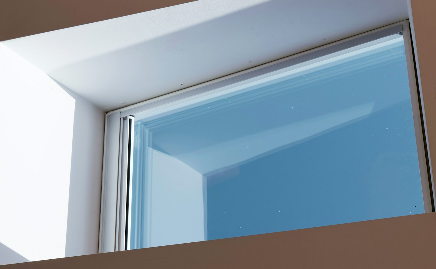 Modern window frame showing a clear blue sky.